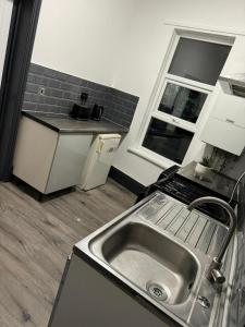 uma cozinha com um lavatório, um fogão e uma janela em Elegant 2-Bedroom Apartment near city centre em Birmingham