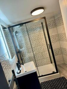 a bathroom with a shower and a white sink at Elegant 2-Bedroom Apartment near city centre in Birmingham