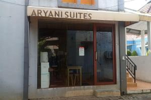 Aryani Suites Syariah في جاكرتا: نافذة متجر عليها لافتة تقرأ أجنحة aanu