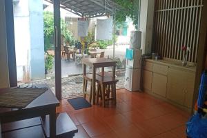 een keuken met een tafel en stoelen en een koelkast bij Aryani Suites Syariah in Jakarta