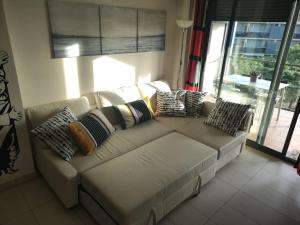 un sofá blanco en una sala de estar con almohadas en Team019 Cambrils Blau Residencial España, en Cambrils