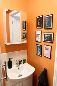 een badkamer met een wastafel en een spiegel bij Studio-Sleeps 4-10 min H Potter-17 Min London in Watford +13 foto's