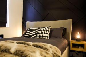 a bed with black and white pillows on it at Boutique Studio Apt 10 Mins H Potter - 17 Mins Ldn in Watford