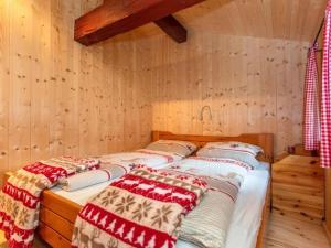 two beds in a room with wooden walls at Almhütte Bairau Kaser in Lofer