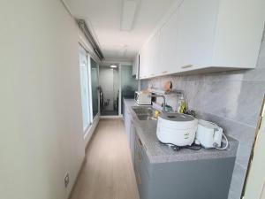 uma cozinha com armários brancos e uma bancada em P house em Seul
