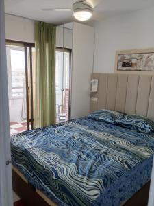 een slaapkamer met een bed met een blauw en wit dekbed bij Miramar Magic Sea & Sunrise view in Torrevieja