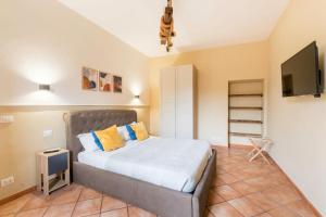 a bedroom with a bed with yellow pillows and a television at FL Apartments Al Mattonato n4 in Rome