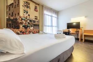 1 dormitorio con 1 cama blanca grande en una habitación en Hotel Pere III El Gran, en Vilafranca del Penedès