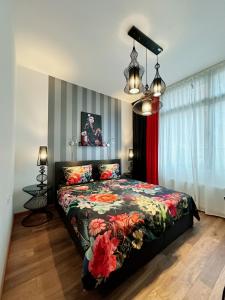 a bedroom with a bed with a floral bedspread at High Level Apartment in Mannheim