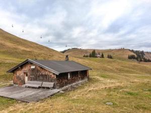 un petit bâtiment sur une colline dans un champ dans l'établissement Almhütte Bairau Kaser, à Lofer