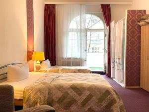 ベルリンにあるホテル カステル アム クアフュルステンダムのベッド2台と窓が備わるホテルルームです。