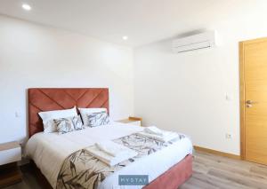 a bedroom with a large bed with white sheets at MyStay - Casa d'Henrique in Vieira do Minho