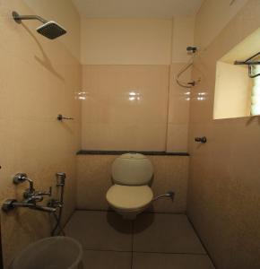 a bathroom with a toilet and a sink at Hotel Rathnavel Towers in Chennai