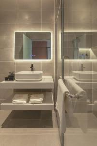 uma casa de banho branca com um lavatório e um espelho em FUHOTEL em Bukit Mertajam