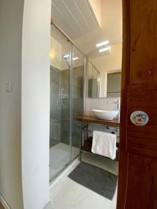 a bathroom with a glass shower and a sink at Levante Flat - 100 m from the beach in Fano