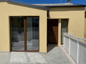 a house with sliding glass doors on a patio at Levante Flat - 100 m from the beach in Fano