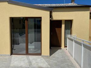 una casa con puertas correderas de cristal en un patio en Levante Flat - 100 m from the beach, en Fano