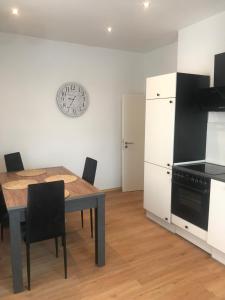 eine Küche mit einem Tisch und einer Uhr an der Wand in der Unterkunft Mimalou Apartment in Zwickau in Zwickau