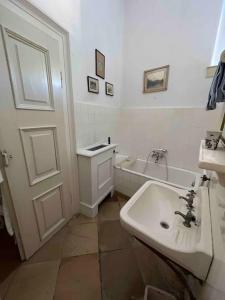 a white bathroom with a sink and a tub at Charming Castle in Austria in Schwertberg