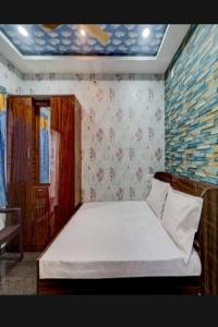 1 dormitorio con 1 cama blanca grande en una habitación en JK Residency, en Padappai