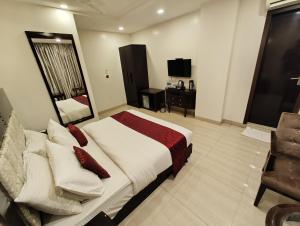 1 dormitorio con 1 cama, 1 silla y TV en Divine Boutique Hotel Panchgani, en Panchgani