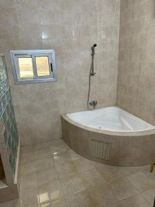 a bath tub in a bathroom with a window at La cave aux variétés in Nouakchott