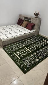 a bed in a room with a rug on the floor at La cave aux variétés in Nouakchott