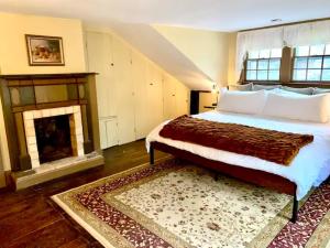 una camera con un grande letto e un camino di INCREDIBLE Northern Westchester Historic Hideaway a South Salem
