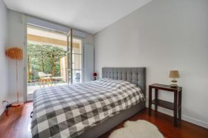 Schlafzimmer mit einem Bett, einem Fenster und einem Tisch in der Unterkunft Le Cocon du Cœur de Ville in Le Plessis-Robinson