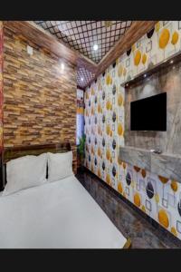 1 dormitorio con 1 cama y TV de pantalla plana en JK Residency, en Padappai