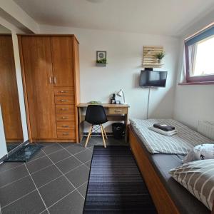 1 dormitorio con 1 cama y escritorio con ordenador en Penzion a Restaurace Simanda en Praga
