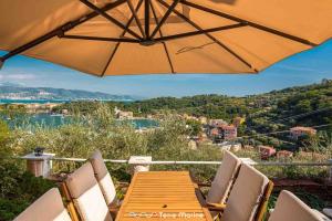 a wooden table with chairs and an umbrella at Il Giardino delle Meraviglie in Le Grazie