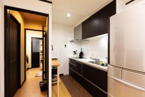a kitchen with black cabinets and a stainless steel refrigerator at 山雲居 in Kyoto