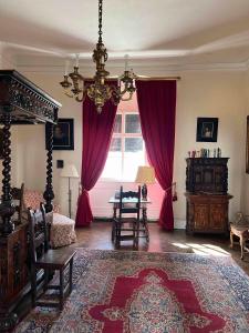 uma sala de estar com um lustre e cortinas vermelhas em Charming Castle in Austria em Schwertberg
