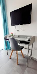 a desk with a tv and a chair in a room at Casa Olla in Quartucciu