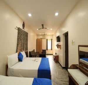 a bedroom with two beds and a living room at Hotel Rathnavel Towers in Chennai