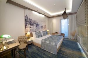 a hotel room with a large bed and a desk and a desk at AHC Ayasofya Hotel - Special Class in Istanbul