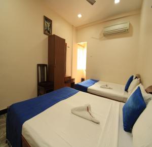 A bed or beds in a room at Hotel Rathnavel Towers