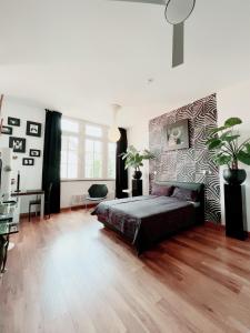 a bedroom with a bed and a wooden floor at High Level Apartment in Mannheim