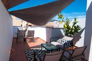 a balcony with chairs and a couch and a table at Apartment with terrace in Malaga Center - TCM in Málaga