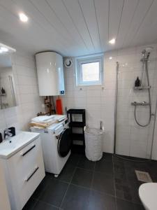 uma pequena casa de banho com um lavatório e um chuveiro em Bålsta Studio Houses em Bålsta