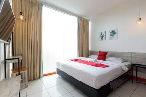 een slaapkamer met een bed en een groot raam bij RedDoorz near Mangga Dua Mall in Jakarta