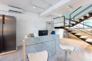 an office with a counter with chairs and stairs at RedDoorz near Mangga Dua Mall in Jakarta