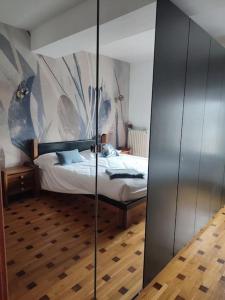 Schlafzimmer mit einem Bett und einer Glaswand in der Unterkunft Neblou in Aosta