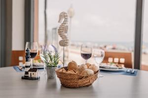 uma mesa com uma cesta de pão e copos de vinho em Hotel Apartamentos Londres La Manga em La Manga del Mar Menor