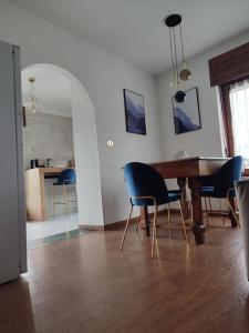 a dining room with a wooden table and blue chairs at Neblou in Aosta