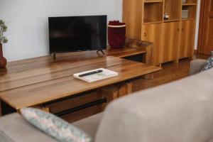 ein Wohnzimmer mit einem Couchtisch aus Holz und einem TV in der Unterkunft Neblou in Aosta
