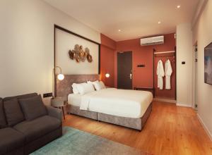 a hotel room with a bed and a couch at FUHOTEL in Bukit Mertajam