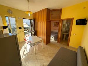 a kitchen and living room with a table and chairs at Villa Paeonia in Paestum