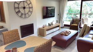 a living room with a large clock on the wall at Parque Botanico Resort in Estepona